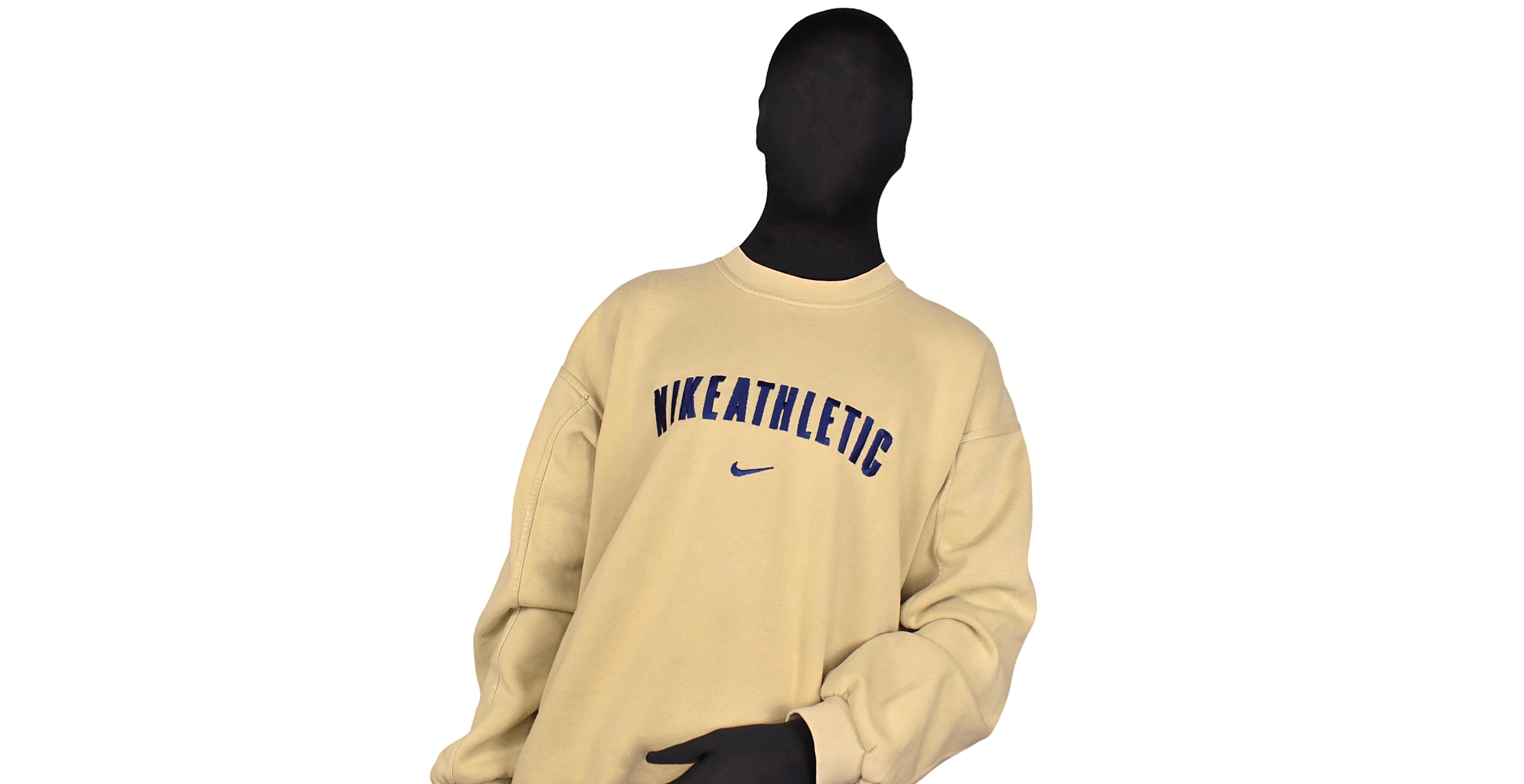 Beige vintage Nike sweatshirt modeled against a clean white background. Elevate your vintage clothing game with this timeless piece from Recovered Vintage online