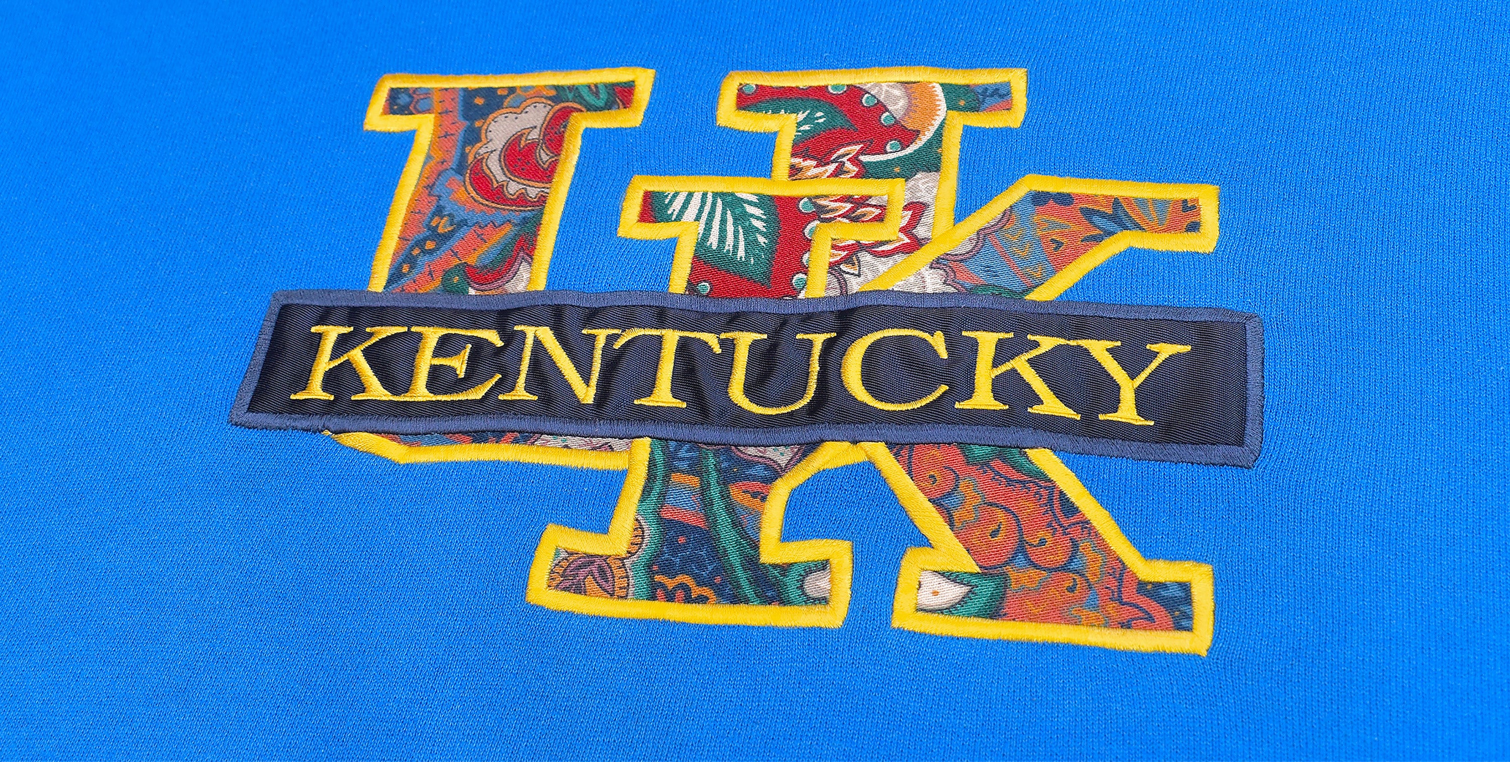 Close-up of embroidered Kentucky University sweatshirt in vibrant blue by Recovered Vintage. Show your college pride in style with this classic piece from our collection